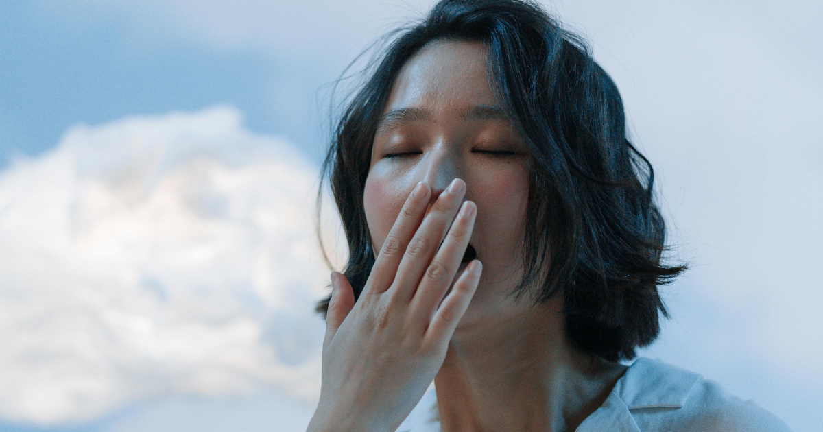 Woman yawning, possibly experiencing side effects or duration insights related to Ketamine nasal spray.