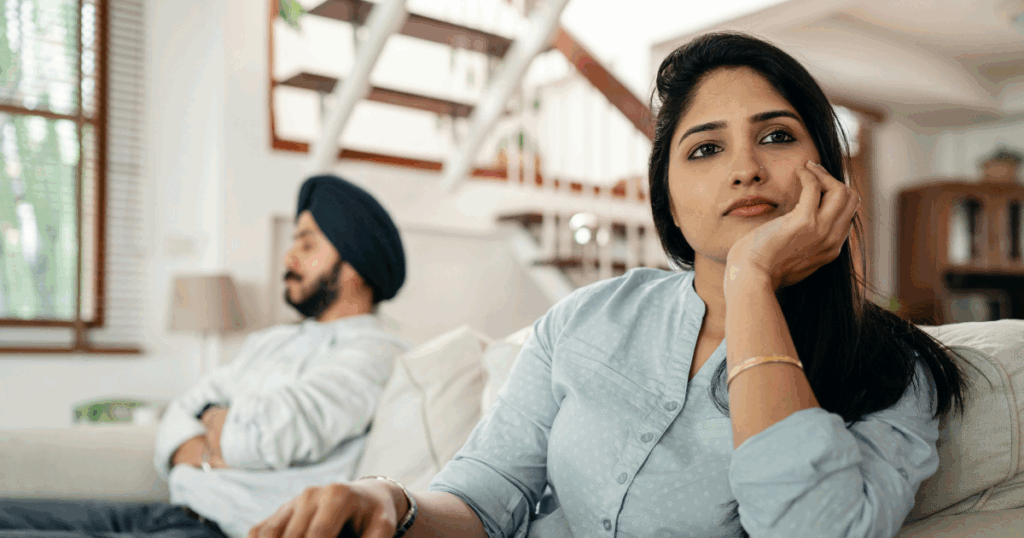 Anxious couple on couch. Woman is in focus, man behind. Ketamine may help managing anxiety. 