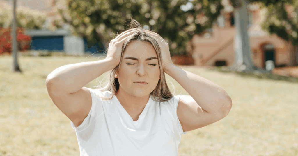 image | Clear Mind Treatment | Comprehensive Mental Healthcare Woman experiencing a Ketamine K Hole, clutching head, eyes closed, feeling disoriented and overwhelmed by the dissociative effects.