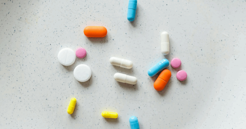 Buspirone medication: colorful pills and capsules scattered on a white surface, representing anxiety relief.